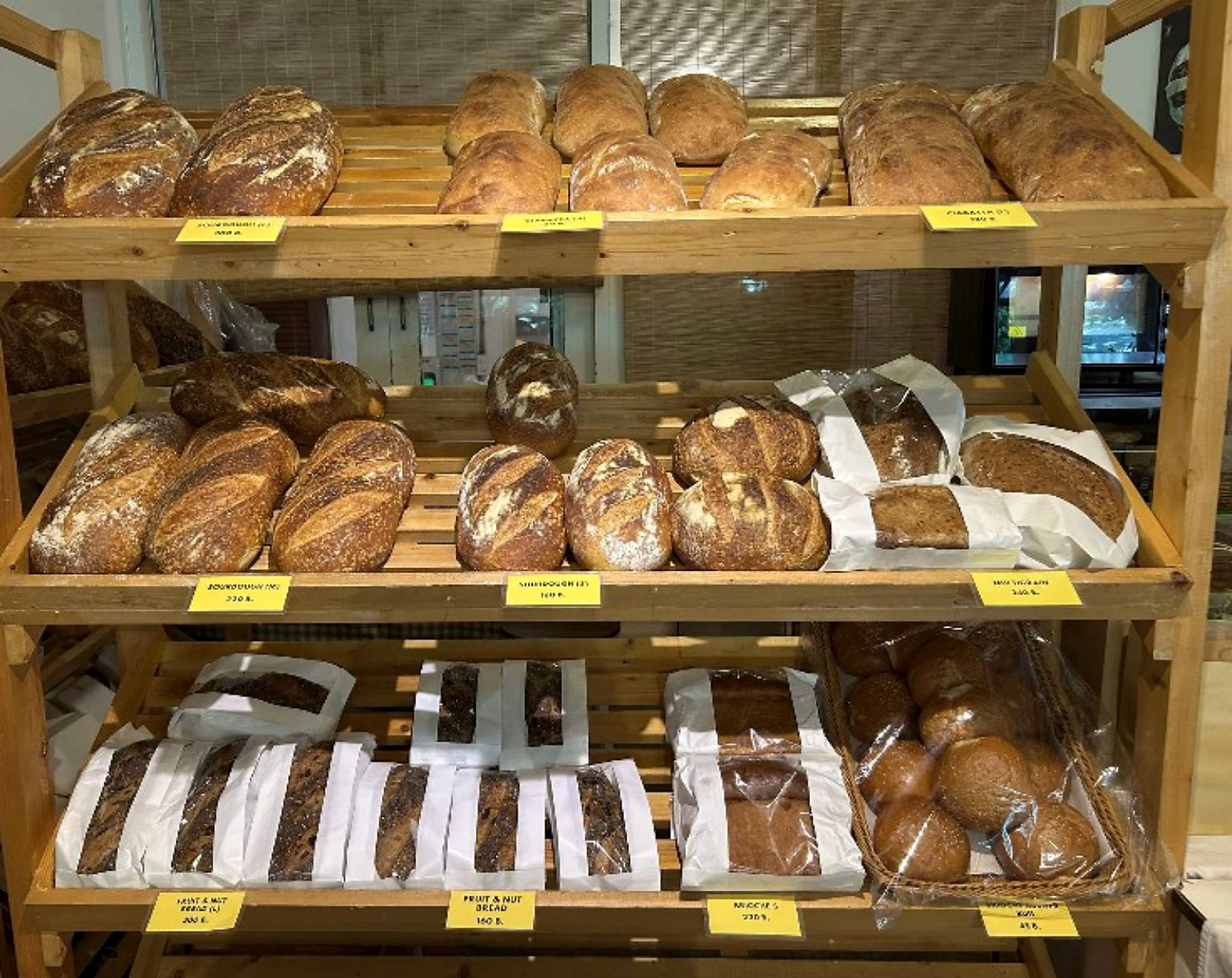 Assorted loaves displayed on bakery shelves